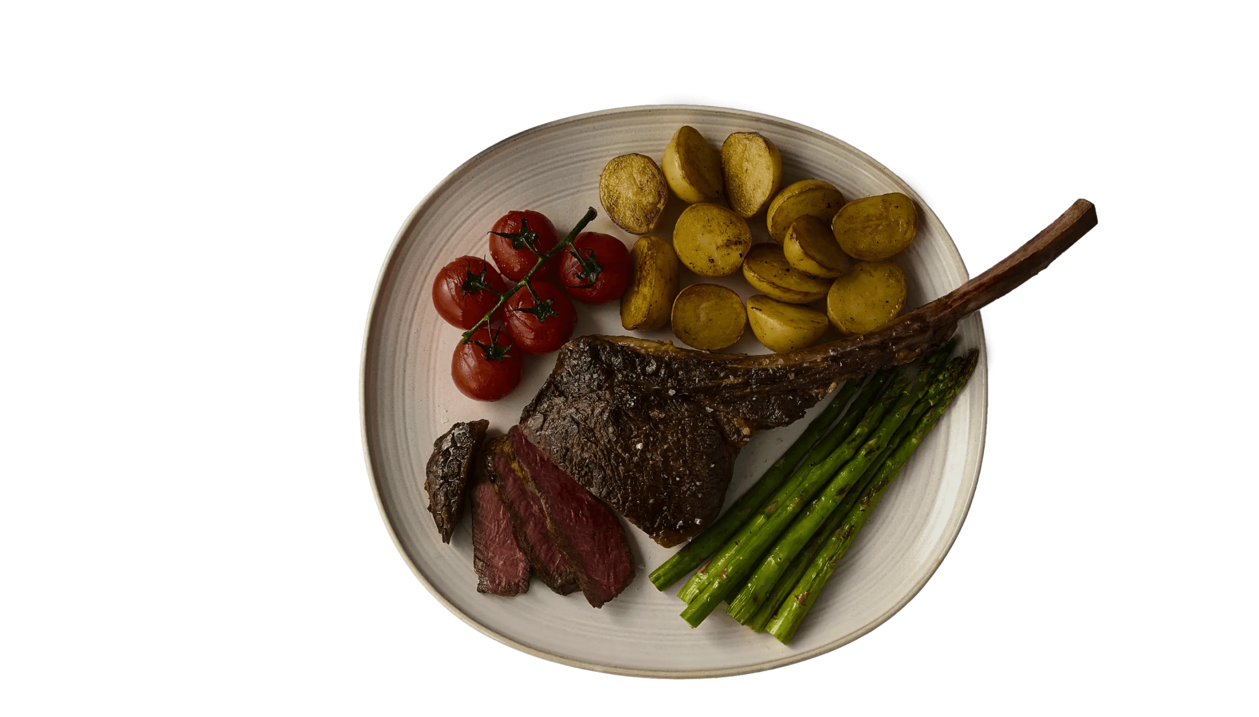 Tomahawk steak dinner with asparagus, potatoes, and tomatoes.