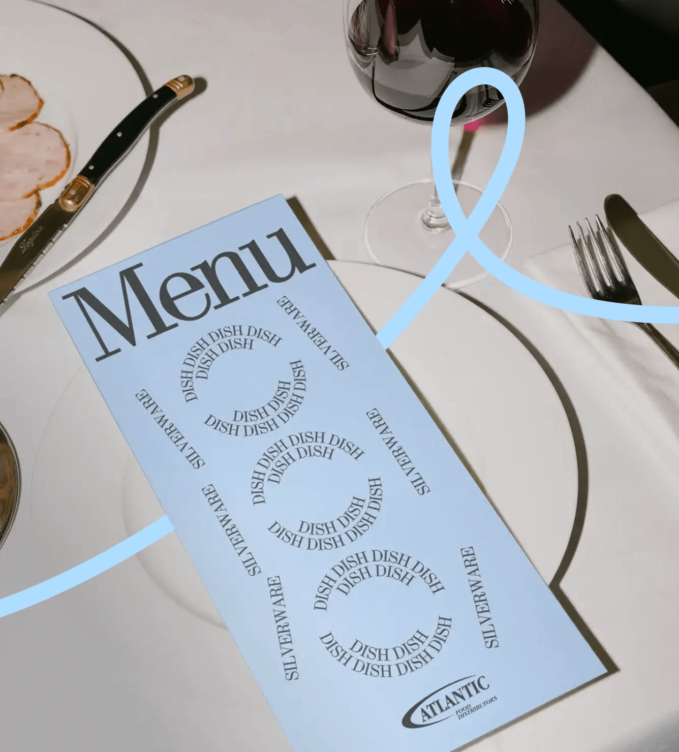 A blue menu labeled Menu lies on a white tablecloth next to a plate with sliced meat, a knife, a fork, and a glass of red wine. The menu repeatedly lists DISH and SILVERWARE in a spiral pattern.