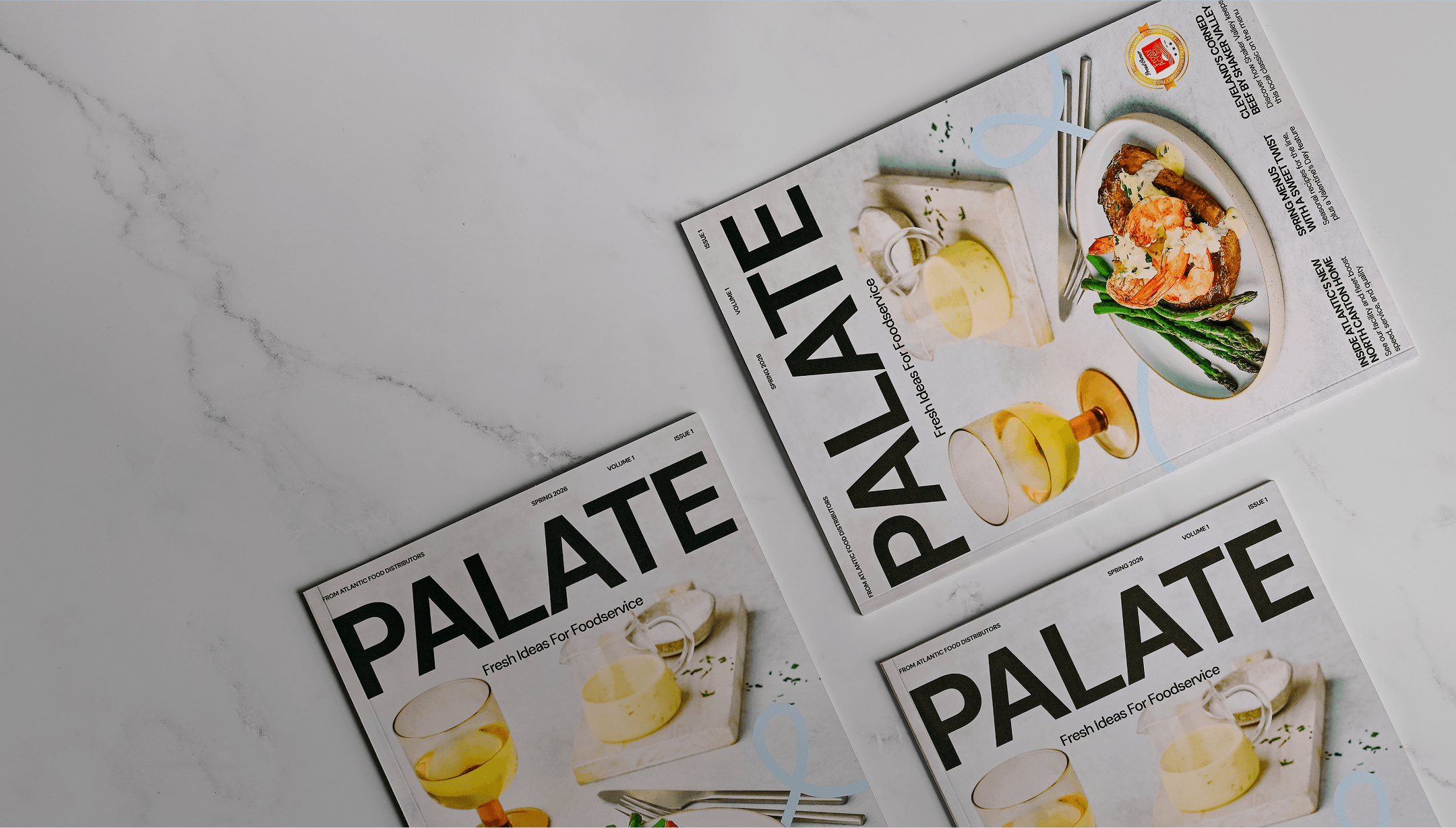 Three PALATE magazines displayed on a marble tabletop featuring a foodservice cover design