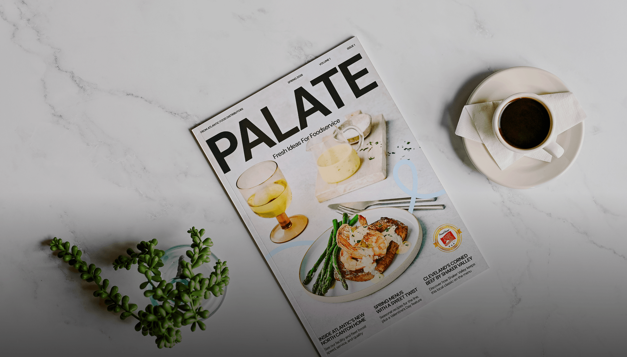 PALATE foodservice magazine on a marble tabletop with coffee cup and succulent plant